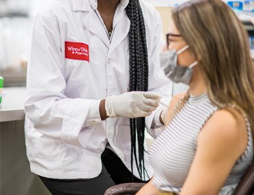Pharmacist giving customer shot