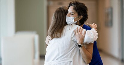 Two physicians joyfully embracing. 