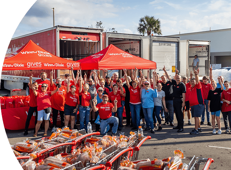 Group of Winn-Dixie gives foundation volunteers joyfully cheering with their arms up.