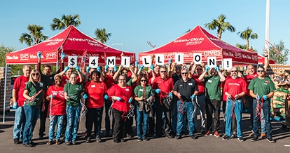 Group of happy Southeastern Grocers' employees holding up signs that read $4 million