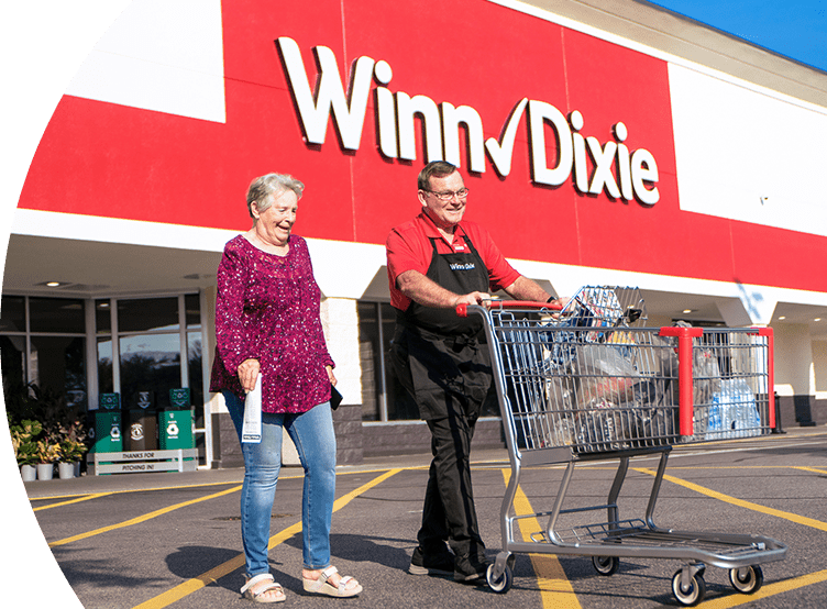 Winn-Dixie employee assisting customer with their groceries.