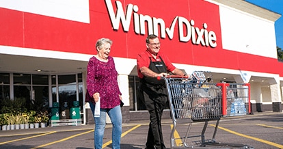 Winn-Dixie employee assisting customer with their groceries.