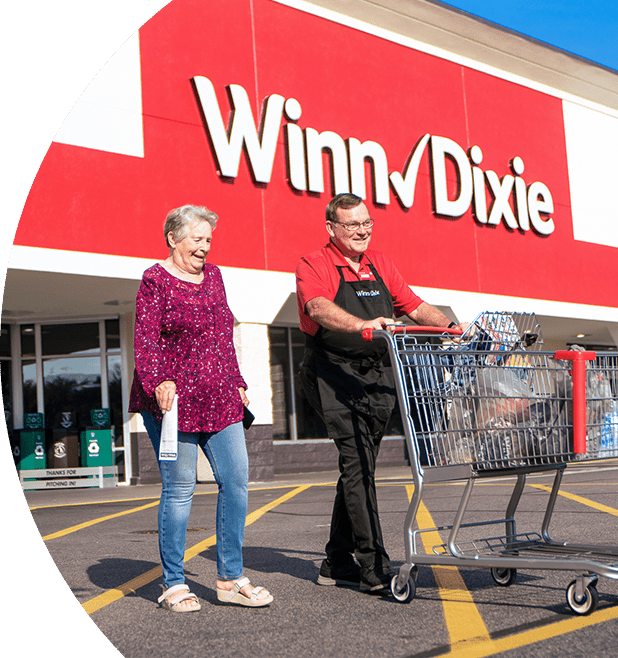 Winn-Dixie employee assisting customer with their groceries.
