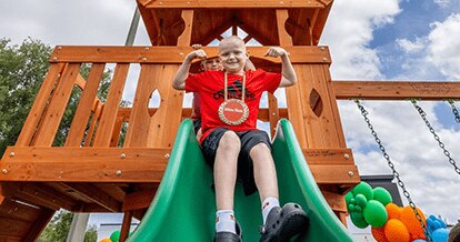 Child smiling going down a slide
