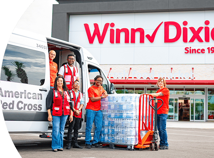 Volunteers assisting with a stack of water bottle donations.