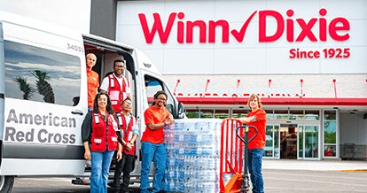 Volunteers assisting with a stack of water bottle donations.