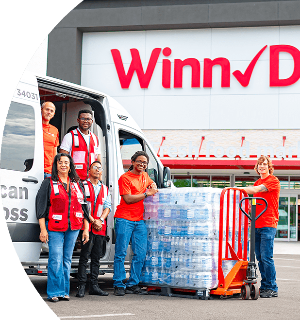 Volunteers assisting with a stack of water bottle donations.