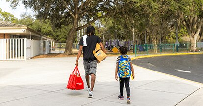 Dad and son carrying Winn-Dixie groceries.