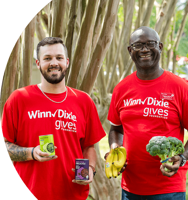 Gives Foundation volunteers joyfully holding canned goods and produce.