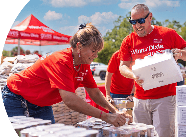 Winn-Dixie gives foundation volunteers assembling packages of canned goods for donation.