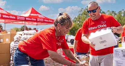 Winn-Dixie gives foundation volunteers assembling packages of canned goods for donation.