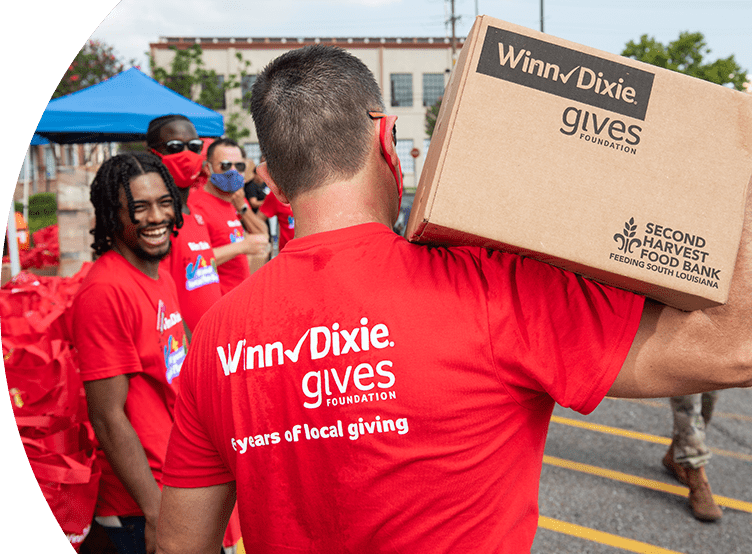 Winn-Dixie Gives Foundation volunteer carrying a box with donations.