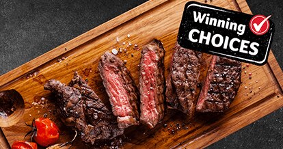Cooked meat cut into pieces placed on a wooden board. 
