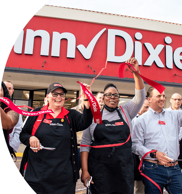 Happy Winn-Dixie employees outside of a storefront with confetti