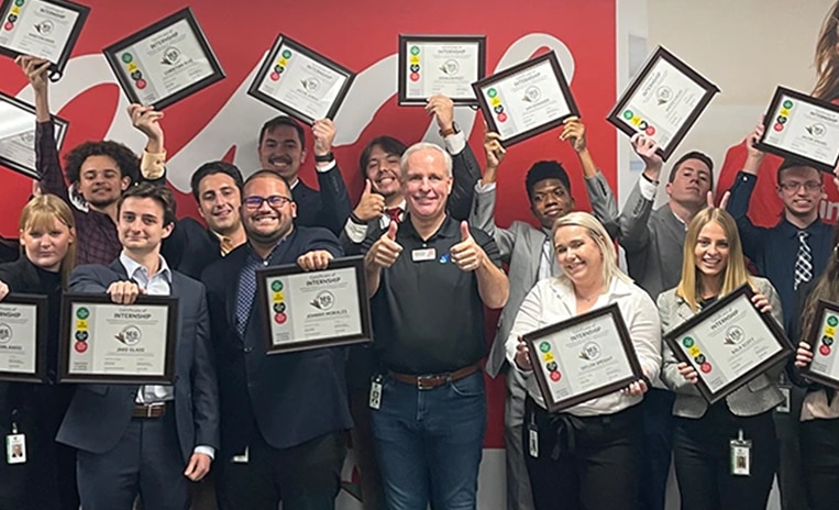 Group of interns holding up diplomas