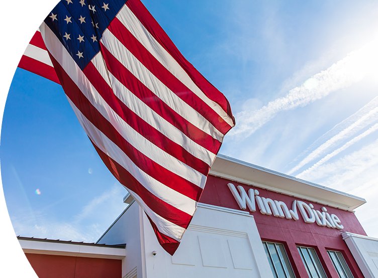 Winn-Dixie storefront with American flag waving out front. 