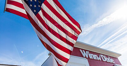Winn-Dixie storefront with American flag waving out front. 